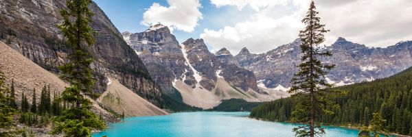 Pine trees and rocky mountains framing a bright blue lake