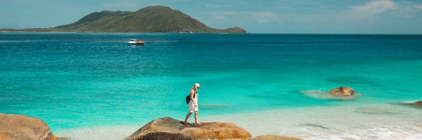 Woman standing on smooth rocks on a beach