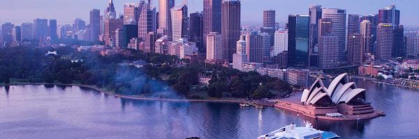 Drone shot of a Royal Caribbean ship docked in front of the Sydney Opera House