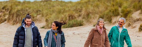 Two couples walking along beach