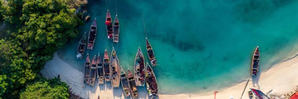 Top down view of wooden rowboats in a deep blue bay