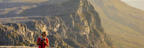 Lady standing at lookout holding binoculars