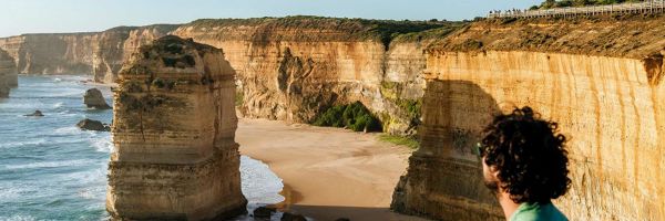 A man at a lookout admiring the view of the 12 apostles