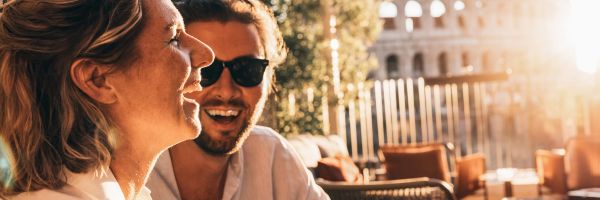 Two people laughing with the Colosseum in the background