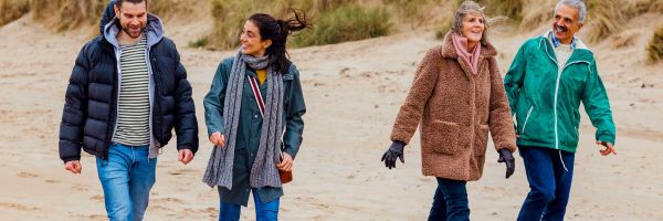 Two couples walking along beach