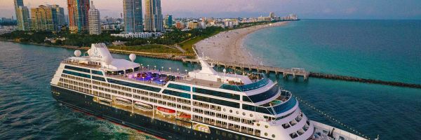 Cruise ship with beach and high-rise buildings in background