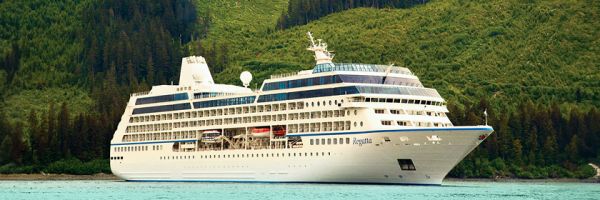 Explorations by Norwegian cruise ship sailing past lush, pine tree covered hillside