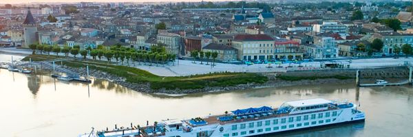 Uniworld River Cruise Ship at sunset next to a European town
