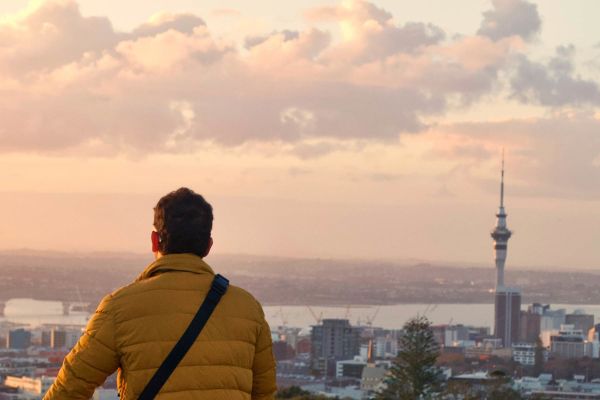Man standing atop Mangere Mountain in Auckland, looking out at the city