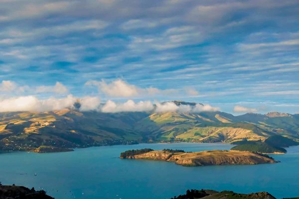 Green field with lakes and mountains in background