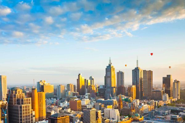 Drone shot of Melbourne city with hot air balloons afar