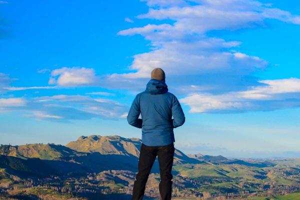 Man standing on rock overlooking mountainous range