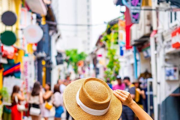 Lady looking out at street market with a straw hat