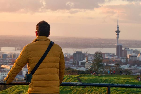 Man standing atop Mangere Mountain in Auckland, looking out at the city