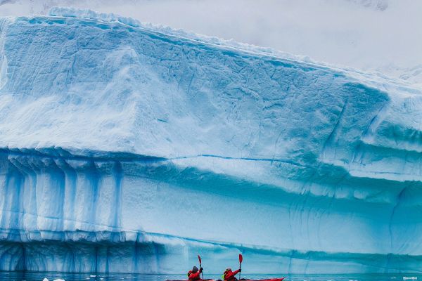 Kayaking next to iceberg