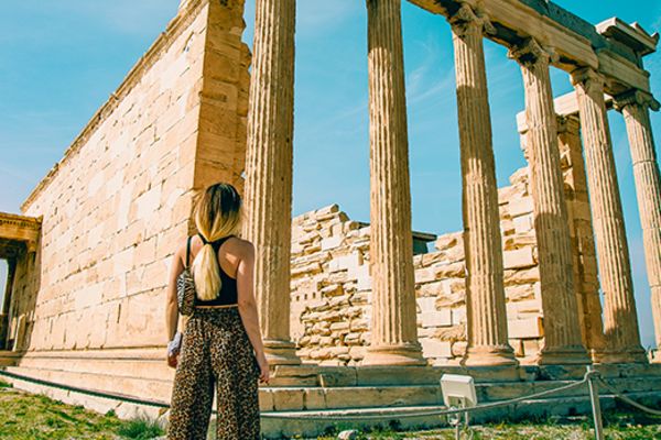lady standing outside of ancient ruins in athens 