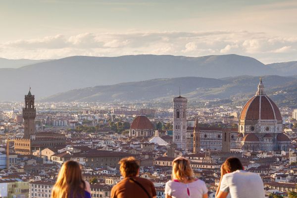 Four young adults sitting looking out at Piazzale Michelangelo in Florence