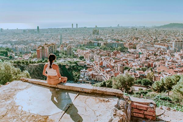 girl sitting on top of building overlooking barcelona