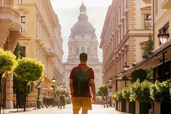 many facing away from camera walking towards large building in budapest