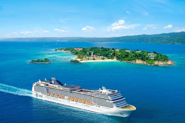 Drone shot of MSC cruise ship cruising past sand island