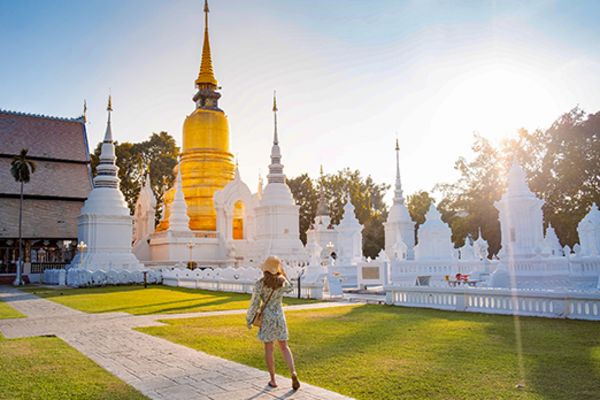 lady walking down path in front of temple in chiang mai