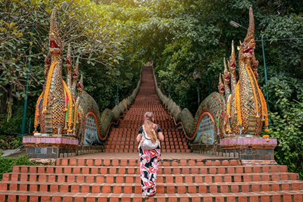 lady walking up stairs towards temple