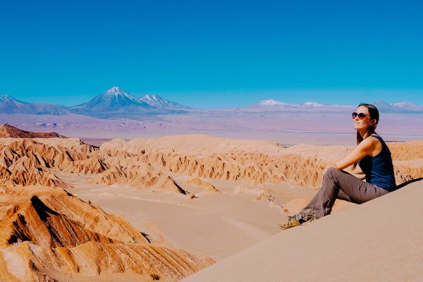Chile, Atacama Desert, woman sitting on a dune looking at view