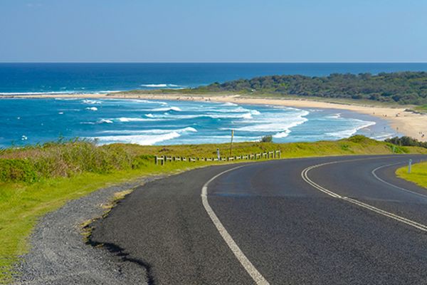Stretch of highway with ocean waves in the background