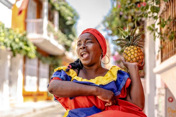 Palenquera walking and dancing on the street in Cartagena, Colombia