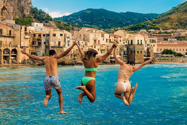Three friends jumping into the ocean