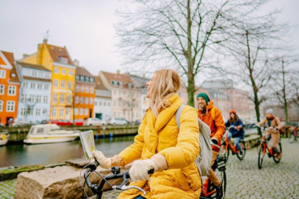 People in warm clothing riding bikes through Copenhagen