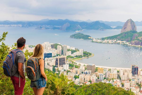 Couple on top of a hill looking down at a coastal town