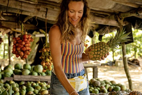 A woman picking out fruit at a fruit stand in Costa Rica