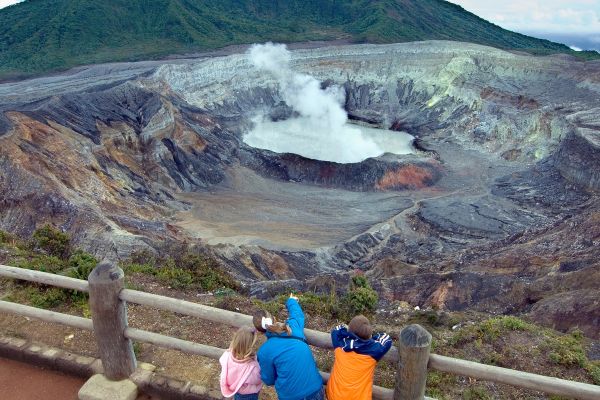 Family of 3 looking at crater