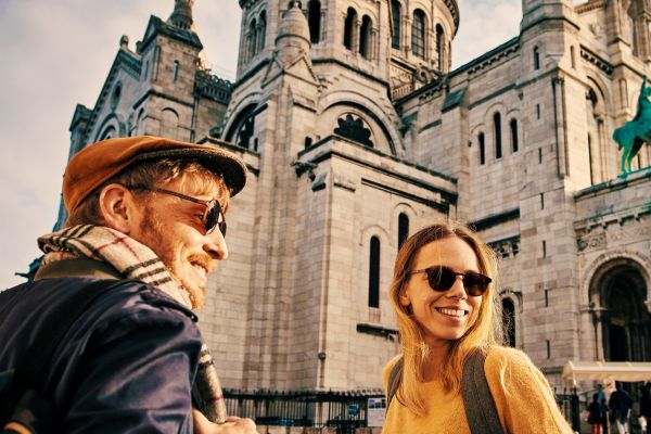 Two people smiling in front of a cathedral in Europe