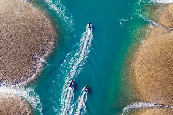 Aerial shot of 3 x boats cruising through water in WA/NT