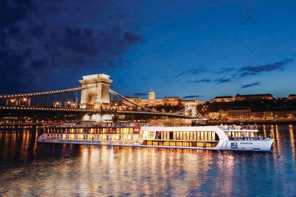 APT river ship travelling under a bridge in the evening