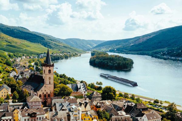 APT river ship cruising past a small town