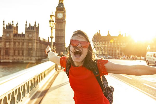 Woman in a red dress cheering in front of Big Ben