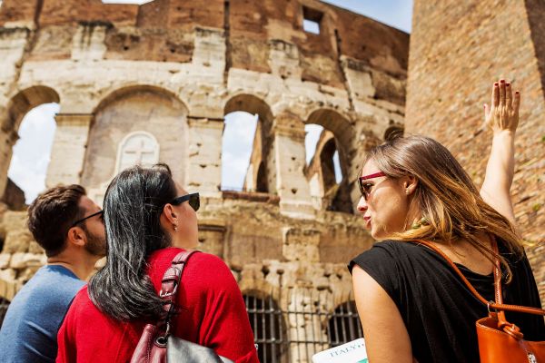 Tour guide teaching tourists about the Colosseum in Rome