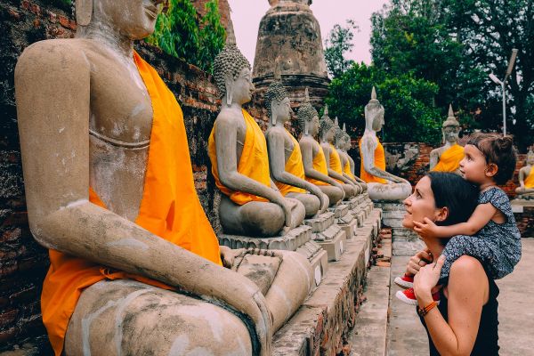Mother and child looking at statues in Thailand
