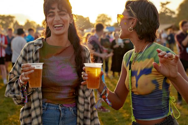Two women drinking beer together at a festival
