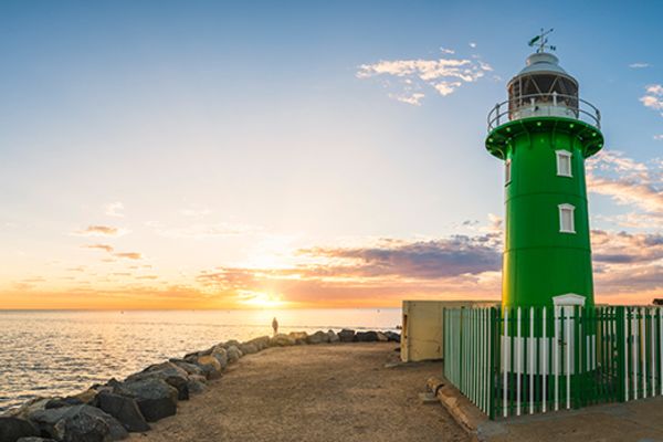 green lighthouse by water at sunset in fremantle wa