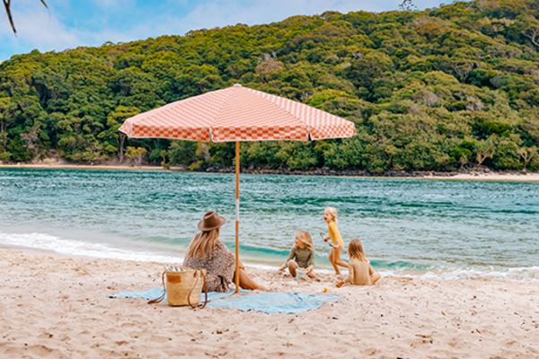 Mother and her children playing on a beach next to a river