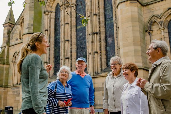 People standing in front of a cathedral listening to a tour guide