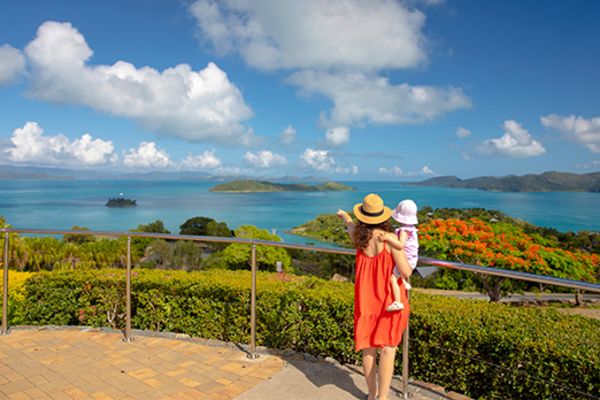 Mother and child looking out at green islands off the coast