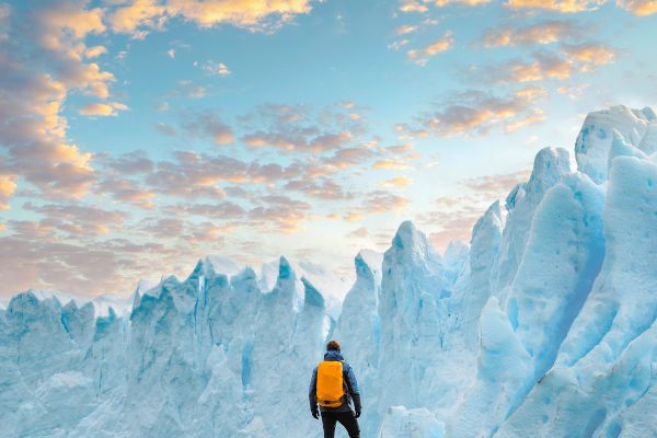 Person hiking looking at tall shafts of ice from a rocky plain