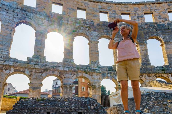 Woman taking a photo from inside ancient ruins
