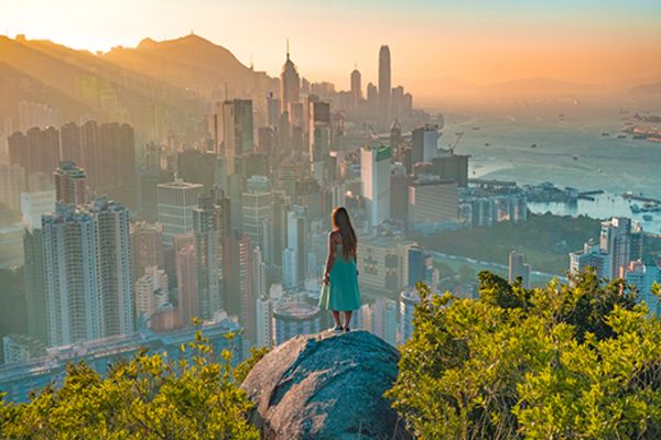 Woman standing on a rock looking out at the city of Hong Kong