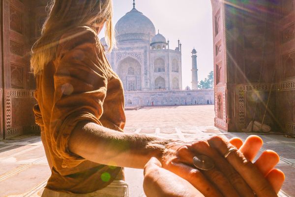 Follow me to the Taj Mahal, India. Female tourist leading boyfriend to there magnificent famous Mausoleum in Agra. People travel concept